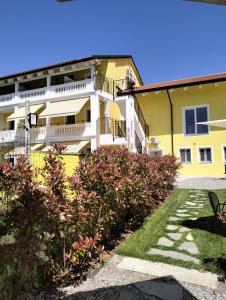 a yellow and white building with a yard at B&B La Barbatella in Palazzo Canavese