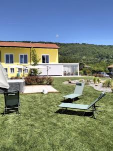 a yard with two lounge chairs and a house at B&B La Barbatella in Palazzo Canavese