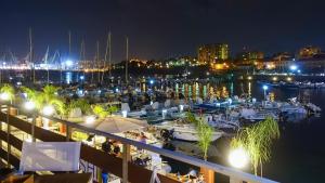 a marina at night with boats in the water at Suiteincenter Rooms in Palermo