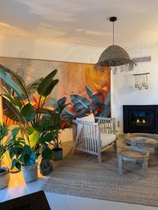 a living room with plants and a painting on the wall at Casa Sol e Sal in Luz
