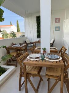 a wooden table and chairs on a patio at Casa Sol e Sal in Luz