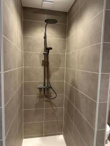 a shower with a shower head in a bathroom at Het Kantoor in Philippine
