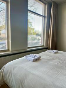 two beds sitting next to a window with towels on them at Het Kantoor in Philippine