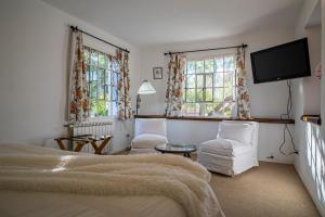 a bedroom with a bed and a flat screen tv at Posada los Cedros in La Cumbre