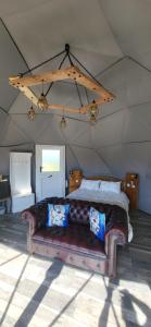 a bedroom with a couch in a tent at alpaca view Dome in New Holland