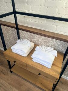 a shelf with three white towels on it at Paruni Trahteri majutus in Viljandi