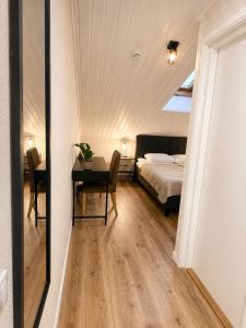 a bedroom with a bed and a desk with a table at Paruni Trahteri majutus in Viljandi