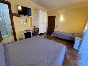a hotel room with two beds and a desk at Il Melograno in Nicotera Marina