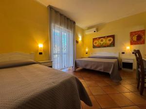 a hotel room with two beds and a window at Il Melograno in Nicotera Marina