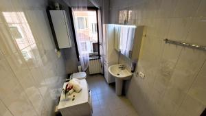 a white bathroom with a sink and a toilet at Calle Bottari ChioggiaPL in Chioggia
