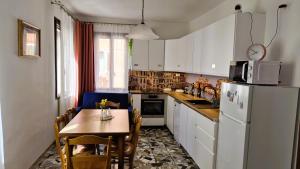 a small kitchen with a table and a refrigerator at Calle Bottari ChioggiaPL in Chioggia