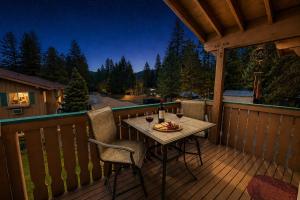 a table on a deck with two chairs and wine glasses at Suite Serenity Condo by NW Comfy Cabins in Leavenworth