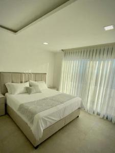 a white bedroom with a large bed and a window at Villa Maja in Sutomore +13 photos