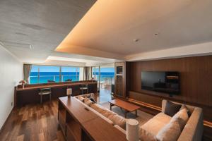 a living room with a couch and a television at RAV RESORT Okinawa in Yomitan