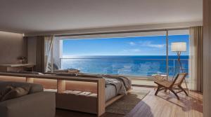 a bedroom with a large view of the ocean at RAV RESORT Okinawa in Yomitan