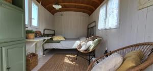 a small room with a bed and two chairs at Petit a Petit - gypsy wagons and Bell tents in the Bourgogne in Saisy