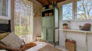a green cabinet in a room with a window at Petit a Petit - gypsy wagons and Bell tents in the Bourgogne in Saisy +33 photos