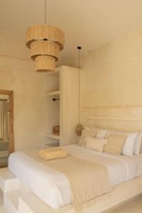 a bedroom with two beds with white sheets and pillows at CASA NARA BALI in Canggu