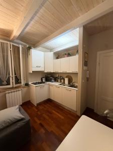 a small kitchen with white cabinets and wooden floors at Martina Fillungo Loft in Lucca