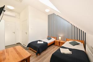 a bedroom with two beds and a wooden table at Marina Grudziądz in Grudziądz
