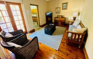 a living room with two chairs and a television at 17 on Bird Guest House in Beaufort West