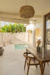 a room with a wooden table and a pool at CASA NARA BALI in Canggu