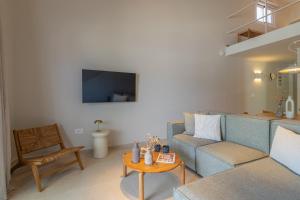 a living room with a blue couch and a table at Cavaliere Seafront House - Thalia in Sami +29 photos