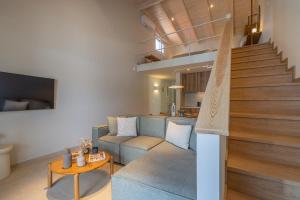 a living room with a blue couch and stairs at Cavaliere Seafront House - Thalia in Sami