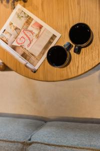 a wooden table with two cups and a magazine at Cavaliere Seafront House - Thalia in Sami