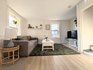 a living room with a couch and a tv at Red Roof Guesthouse in Cobourg