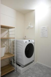 a computer monitor sitting on top of a dryer in a room at 北鎌倉駅徒歩圏 観光便利 最大7名 2寝室 広々滞在 101 in Kamakura