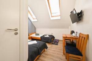 a room with two beds and a desk and a tv at Marina Grudziądz in Grudziądz