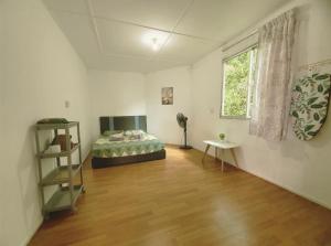 a bedroom with a bed and a table and a window at D' Limbai Cottage in Ranau