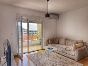 a living room with a couch and a table at Maison Budva in Bečići +1 photo
