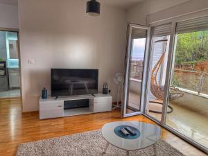 a living room with a large flat screen tv at Maison Budva in Bečići