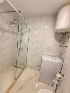 a bathroom with a glass shower and a toilet at Maison Budva in Bečići