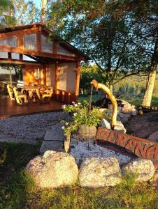a log cabin with a porch and some rocks at La Serena casa de campo y senderismo in Villa Serrana