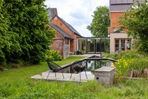 a garden with a pool and a sculpture in front of a house at Viktoria Guesthouse in Westerlo