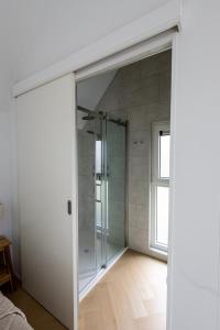 a glass shower in a room with a window at Wad & Loft unieke paalwoning vlakbij de Waddenzee in Pietersbierum +51 photos