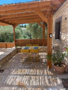 a patio with a table and chairs under a wooden pergola at Mikro kastro in Apergátika +7 photos
