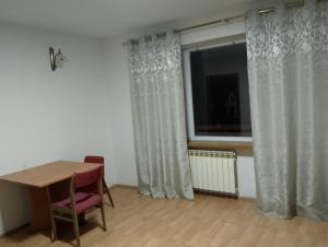 a room with a table and a window with curtains at GM Room in Altanka