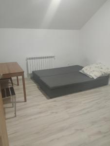 a bedroom with a bed and a desk and a table at GM Room in Altanka