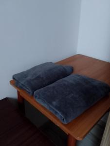 a wooden table with two blue pillows on it at GM Room in Altanka