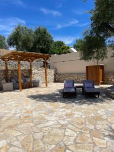 a patio with two chairs and a wooden shelter at Mikro kastro in Apergátika