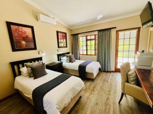 a hotel room with two beds and a desk at 17 on Bird Guest House in Beaufort West +96 photos