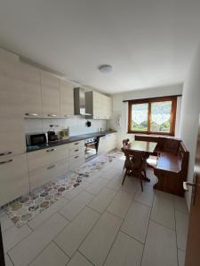 a large kitchen with a wooden table and a window at Appartamento sole in Isone