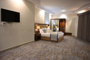 a hotel room with a bed and a flat screen tv at فندق دوما - Domma hotel in Medina