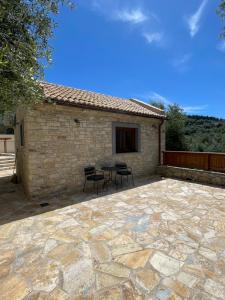 a patio with a table and chairs in front of a building at Mikro kastro in Apergátika