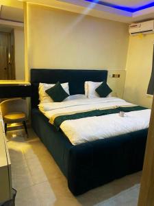 a large bed in a room with a blue ceiling at NH Norvits Hotel in Agbor