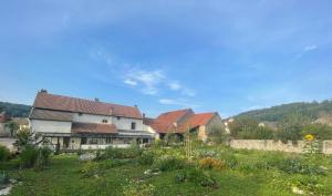a house with a garden in the foreground at Cense des Possibles, Forêt et Prairie in Darcey